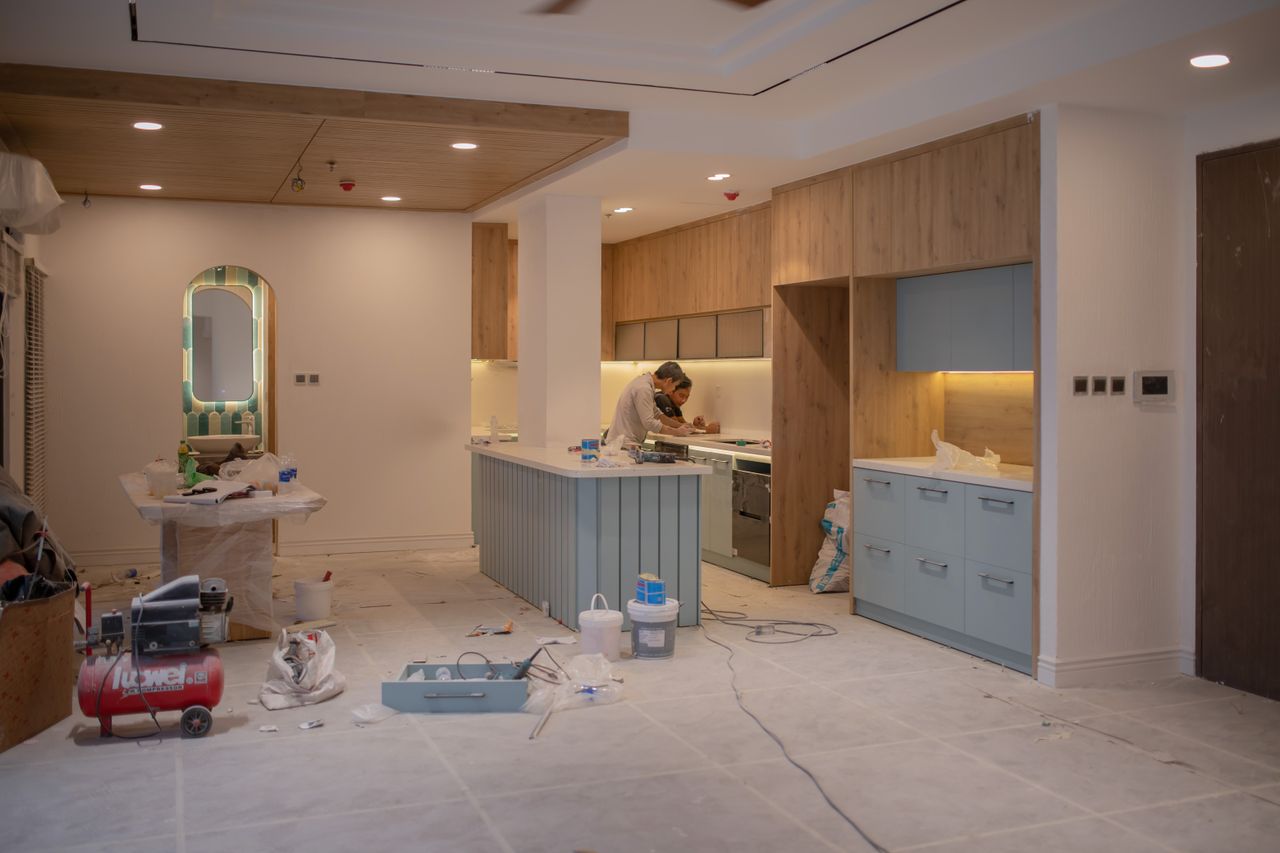 Une cuisine contemporaine en cours de rénovation, avec un artisan, des outils et des matériaux.